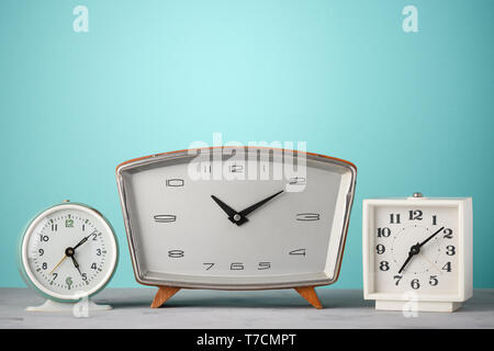 Retro clocks in a row on a table with blue background time concept Stock Photo