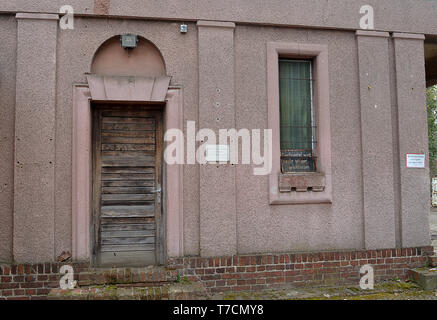 BERLIN, GERMANY - 3 APRIL 2019: A long closed up and derelict entrance to the graveyard of the Jewish community in Berlin (the Weissensee cemetery), Stock Photo