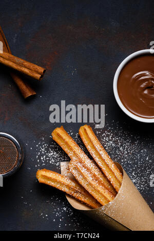 Traditional chrurro sticks hot with chocolate sausce and cinnamon flat lay copy space Stock Photo