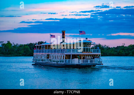 Orlando, Florida. April 23, 2019. Disney Ferry boat in blue lake on colorful sunset background at Walt Disney World  (1) Stock Photo