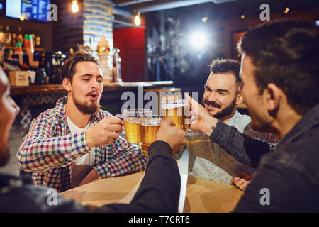 Friends talk, drink beer in a bar. Stock Photo