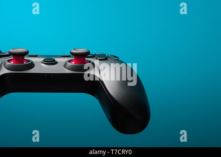 Game controller joy stick. Video game pad retro toned on blue background with copy space. Stock Photo