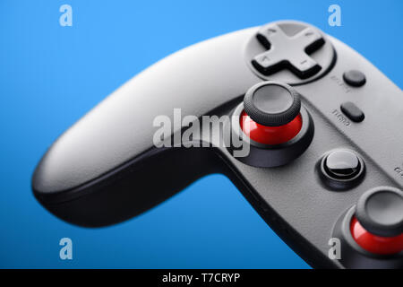 Video game controller. Game pad player joystick closeup on blue background. Stock Photo