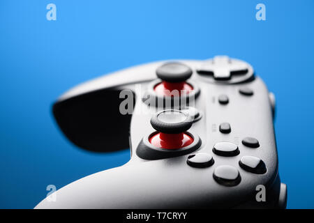 Game pad. Modern video game controller. Joy stick on blue background with copy-space. Stock Photo
