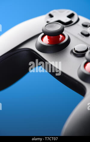 Video game controller. Game pad joystick closeup on blue background. Stock Photo
