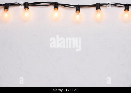 Light bulbs retro garland border on white wall Stock Photo