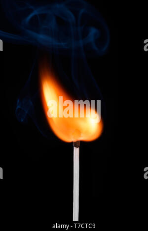 Burning match stick with fire and smoke isolated on black background Stock Photo