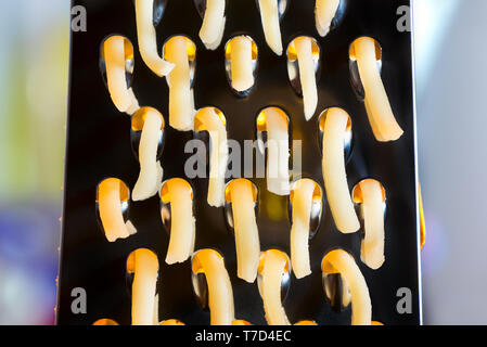 Close up of cheese coming out of a cheese grater Stock Photo