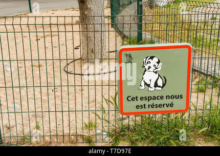 SAN RAPHAEL, FRANCE - APRIL 2019: Sign on a sandy fenced off area on the promenade in San Raphael reserved for dogs to go to the toilet. Stock Photo