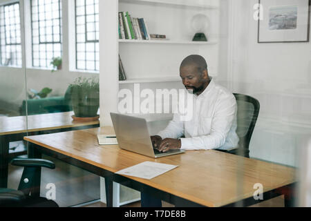 Manager working on a laptop at his office desk Stock Photo