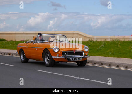 1974 70s Yellow MG B at Cleveleys Spring Car Show at Jubilee Gardens. A new location for Classic cars, veteran, retro collectible, restored, cherished old timers, heritage event, vintage, automobile Vehicle show by Blackpool Vehicle Preservation Group (BVPG). Stock Photo