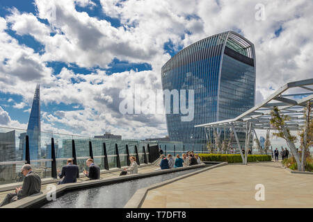 People enjoying the sunshine at The Garden at 120 , a roof garden in the City of London on the roof of Fen Court office building, London,UK Stock Photo