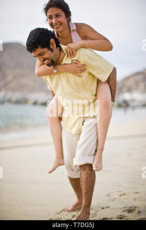 Man piggy backing girlfriend at the beach Stock Photo - Alamy