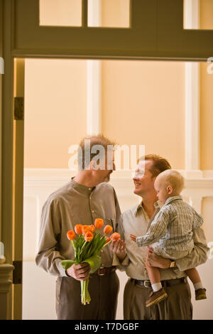 Happy homosexual male couple with a young toddler. Stock Photo