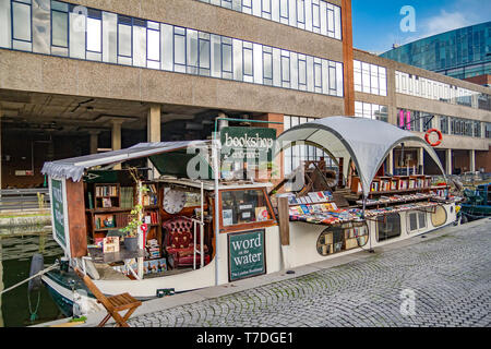 A floating bookshop on a narrow boat moored up on the tow path of the Paddington arm of The Grand Union Canal,Paddington Basin London,UK Stock Photo