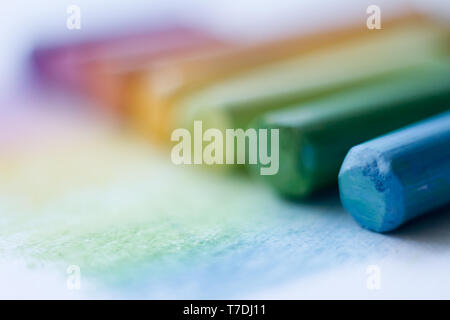 Extreme close-up of multicolored pastel chalks on a white surface, selective focus Stock Photo