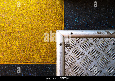 A silver steel plate that crosses a yellow plate on a graphite background. Intersecting plates form rectangles. Great abstract shapes. The perfect tex Stock Photo