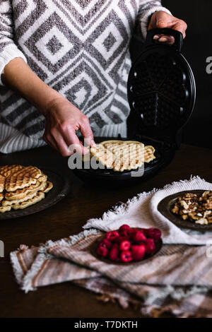 WOMAN IS MAKING DELICIOUS WAFFLES Stock Photo