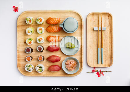 Japanese cuisine. Sushi set on a bamboo plate over white background, flat lay, top view Stock Photo