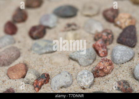spiral pattern made of pebbes on sand background Stock Photo