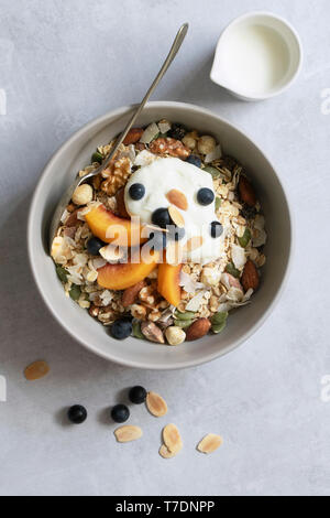 Fresh sliced peaches, blueberries and toasted almonds on a bowl of breakfast cereal. Stock Photo