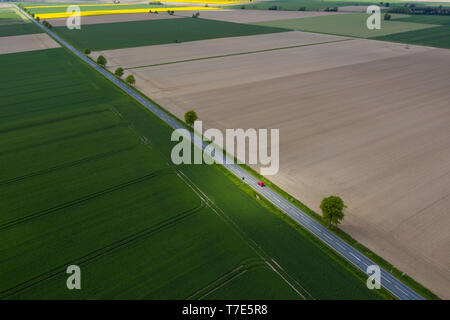 07 May 2019, Lower Saxony, Pattensen: A car drives on a country road between fields. (Aerial photograph with drone) Photo: Christophe Gateau/dpa Stock Photo