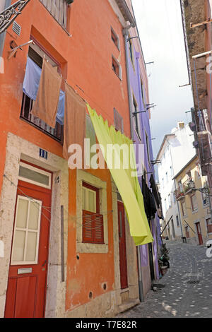 Lime green sheet washing hanging outside a colourful house in Alfama Lisbon Portugal Europe EU  KATHY DEWITT