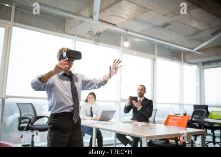 Businessman making gestures when wearing virtual goggles Stock Photo