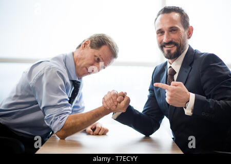 Two businessmen doing arm wrestling in office Stock Photo