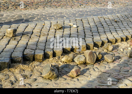 granite cobblestone pavement repair in city street, fragment of destroyed pavement Stock Photo