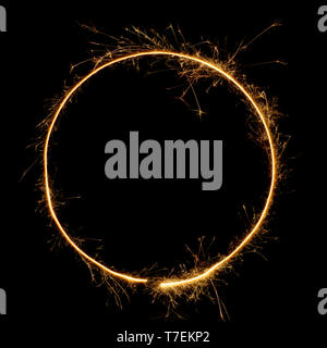 Sparkler circle shape frame. Burning bengal fire round letter o number zero, long exposure. Burning sparklers isolated on black. Stock Photo