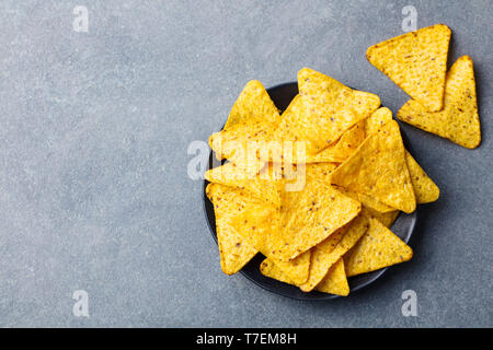Nachos chips in bowl. Grey stone background. Top view. Copy space. Stock Photo