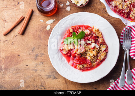 Crumble with berries. Brown wooden background. Top view. Copy space.