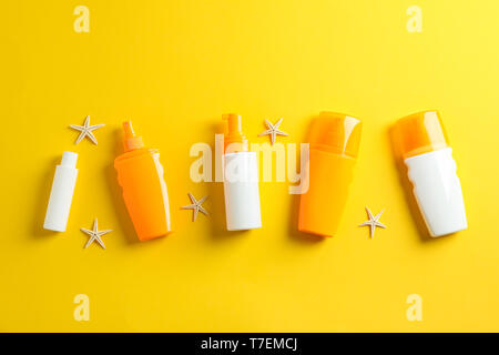 Flat lay composition with sunscreen sprays and starfishes on color background, space for text. Summer vacation backdrop Stock Photo