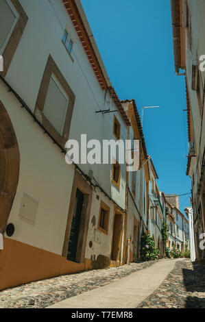 Facade of old houses in cobblestone alley on slope at Castelo de Vide. Nice town with medieval castle at the Portugal eastern border. Stock Photo