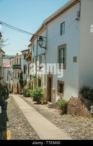 Facade of old houses with whitewashed wall in alley on slope at Castelo de Vide. Nice town with medieval castle at the Portugal eastern border. Stock Photo