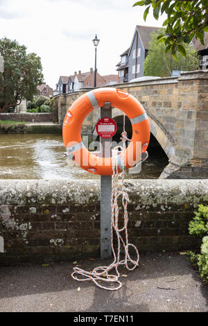 A life ring and rope on the side of a canal Stock Photo