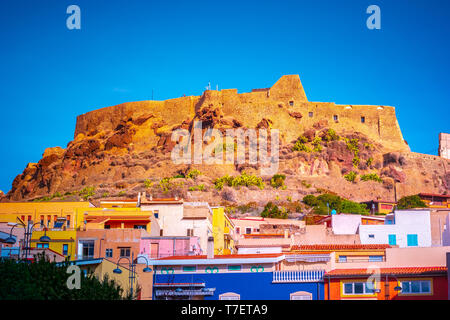 The picturesque town of Castelsardo with colourful houses, a bell tower and a fortified castle, surrounded by the Mediterranean Sea and glowing in the Stock Photo