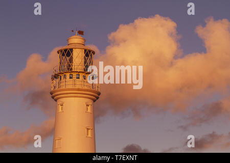 View of Flamborough lighthouse at sunset in blue sky and pink light of the setting sun, East Yorkshire, UK Stock Photo