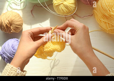 Young woman knitting clothes at table, closeup Stock Photo