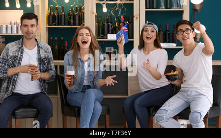 Friends with beer emotionally watching sports in bar Stock Photo