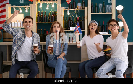 Friends with beer emotionally watching sports in bar Stock Photo