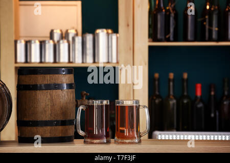 Barrel and glasses of beer on table in bar Stock Photo