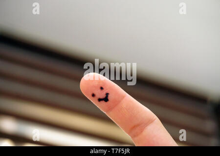 Smile drawing on the woman finger having fun at home close up view Stock Photo
