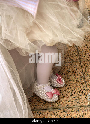 Babygirl on her first birthday party with tulle skirt and slippers Stock Photo