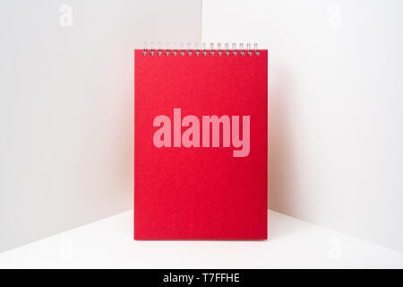 Design concept - perspective view of red spiral notebook, white page on white 3D space background for mockup, it's real photo, not 3D render Stock Photo