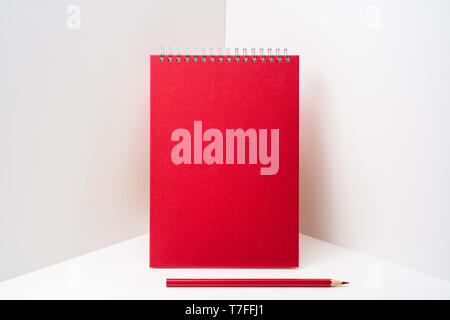 Design concept - perspective view of red spiral notebook, white page on white 3D space background for mockup, it's real photo, not 3D render Stock Photo