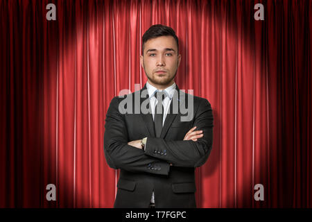 Young businessman on red stage curtains background Stock Photo