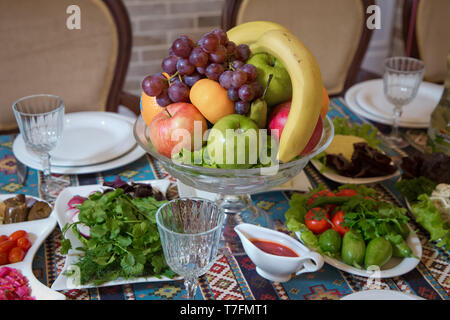 Red and blue apple, orange, red banana banana. Cucumber, tomato, greens, radish. Fruit in a bowl . Stock Photo