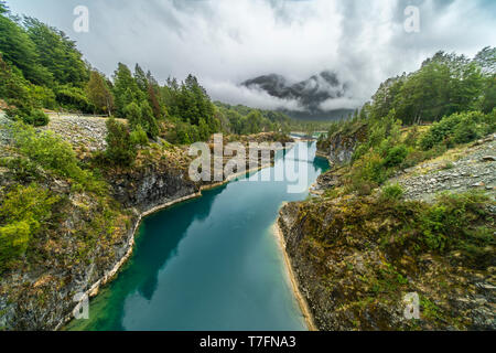 Awe hanging bridge at north Chilean Patagonia, Puelo river moves around the narrow gorge with its turquoise waters on an awe idyllic environment Stock Photo
